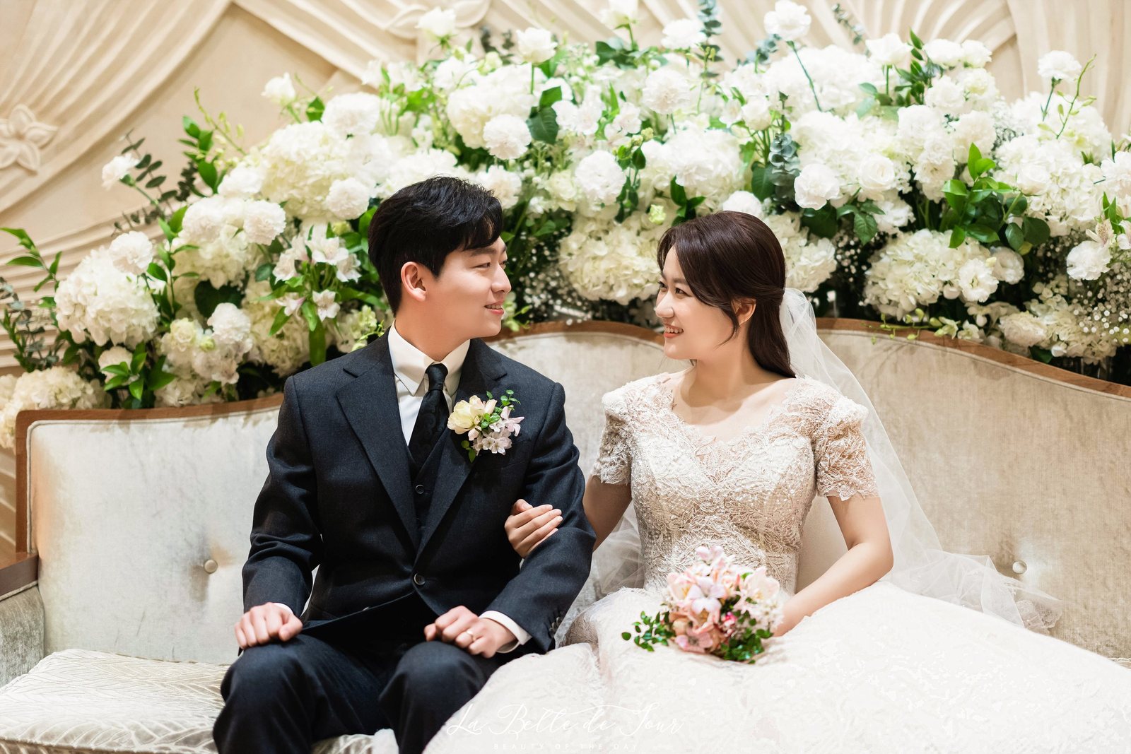 라벨드쥬 광화문 아펠가모 본식스냅 — 주름진 부조 벽 앞 커플